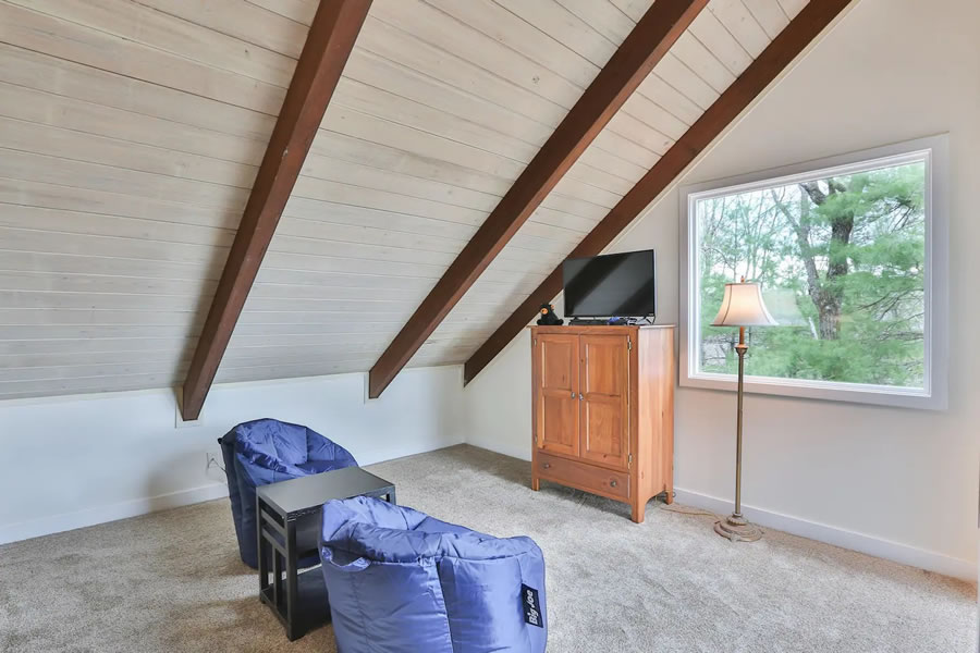 The loft area of Appalachian Sky Mountain Cottage Rental in Big Canoe, Georgia is perfect for the kids with two single beds, TV, and gaming station